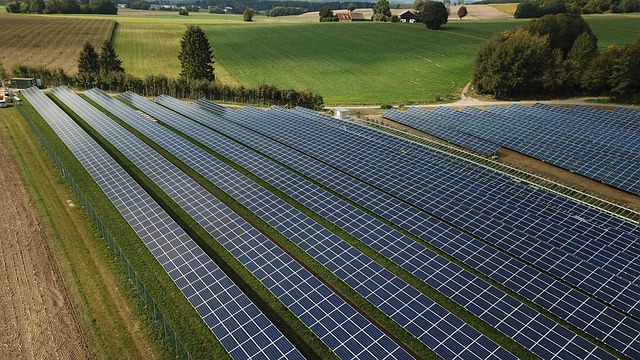 Ein großer Solarpark in Schleswig-Holstein besticht durch Reihen von Photovoltaik-Modulen, die sich über die grüne Landschaft erstrecken und so nachhaltige Energie mit dem ländlichen Charme der Gegend verbinden.